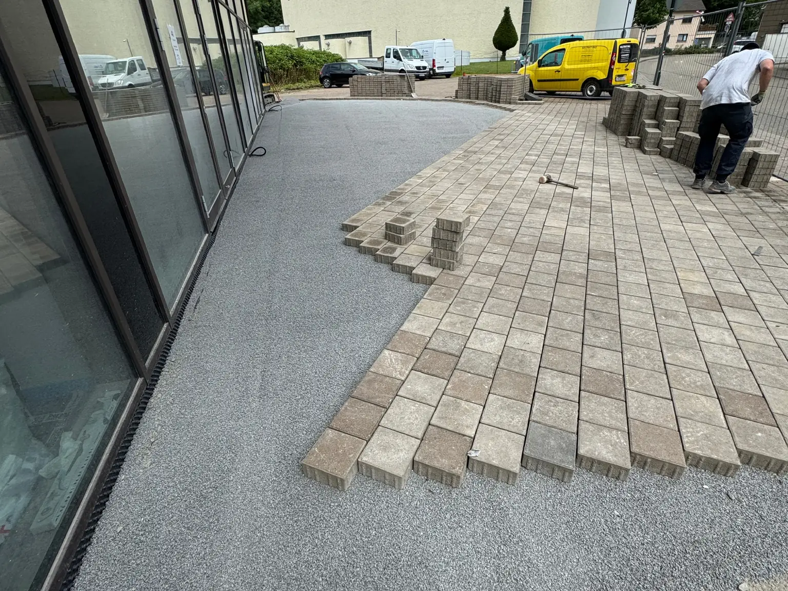 Pflasterarbeiten an einer Hofeinfahrt entlang einer Gebäudefassade